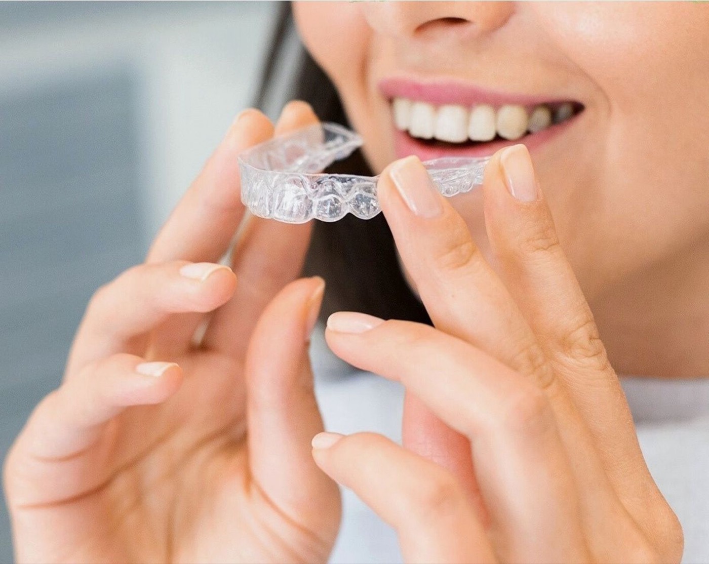 Frau hält transparente Zahnschiene – Aligner-Kosten in Wien