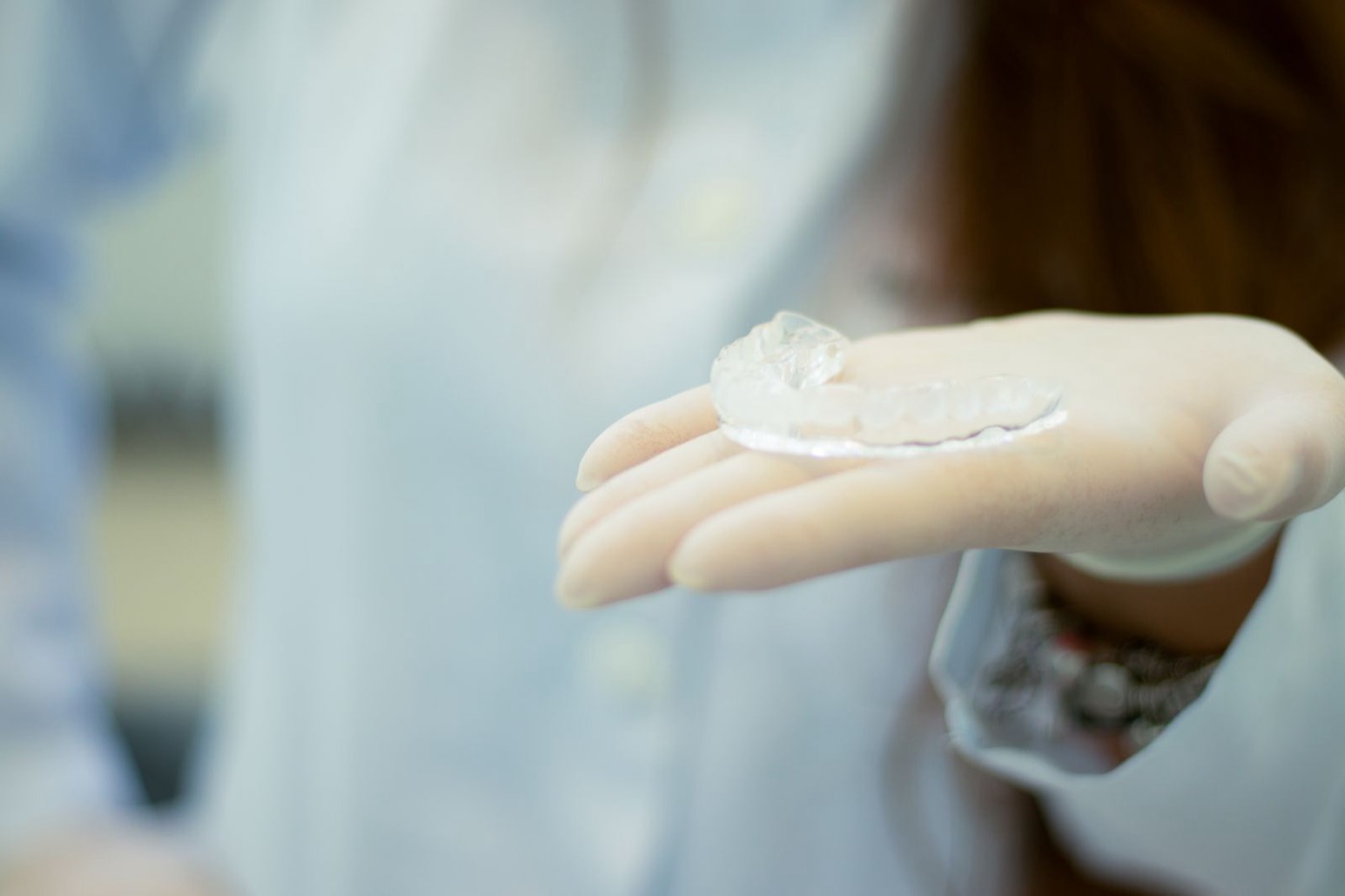 Transparente Knirscherschiene in der Hand des Zahnarztes